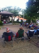 guest sitting in camping chairs listening to man and woman play music